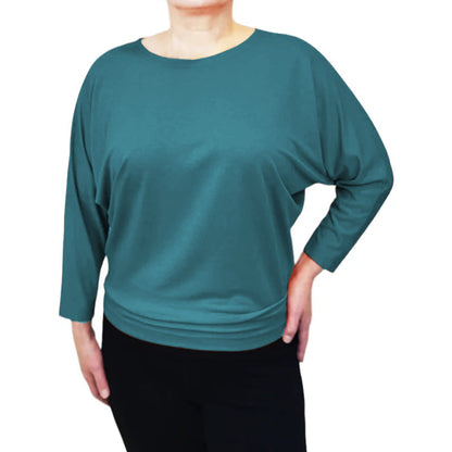 Torso view of a woman wearing the Jo Slouch Tee by Mandala in Lagoon, standing in front of a white background 