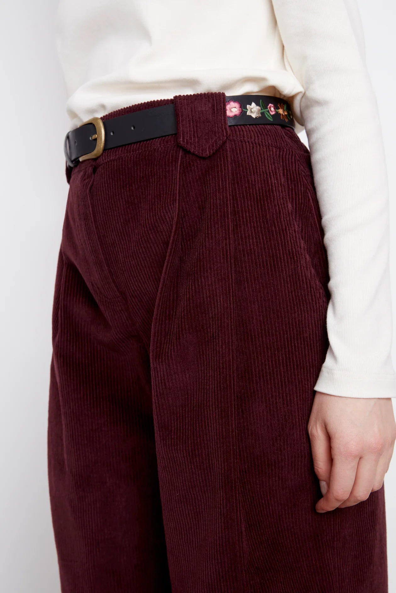 Close up of the waist and legs of the Idadora Pants by Julei in Bordeaux, wide-leg corduroy pants.