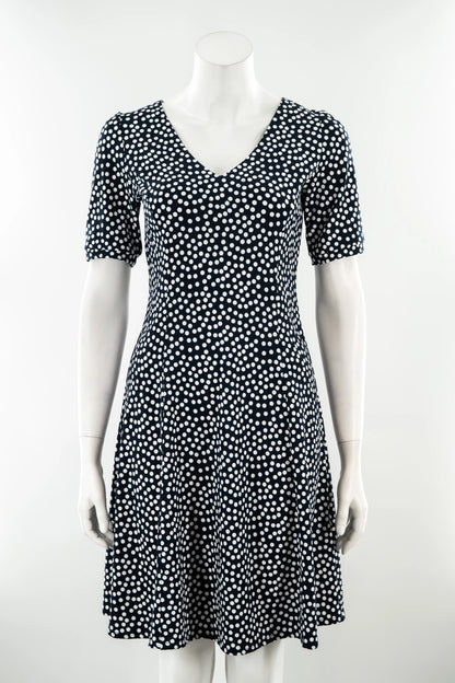 The Navy Polka Dot Dresss by Karkass is shown on against a white background. It has a v-neck, short sleeves, princess seams, and an above the knee hem. 