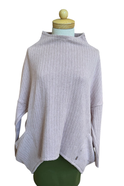 The Meeso Sweater by MOOVment in Lilac, a One Size oversized knit sweater with a wide mock turtleneck, long dropped sleeves and large side pockets, is shown on a mannequin in front of white background. 