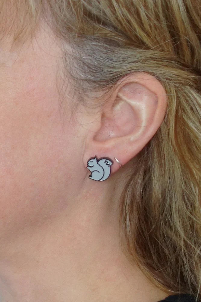 Person wearing a small black and gre Lilipop Squirrel earring.
