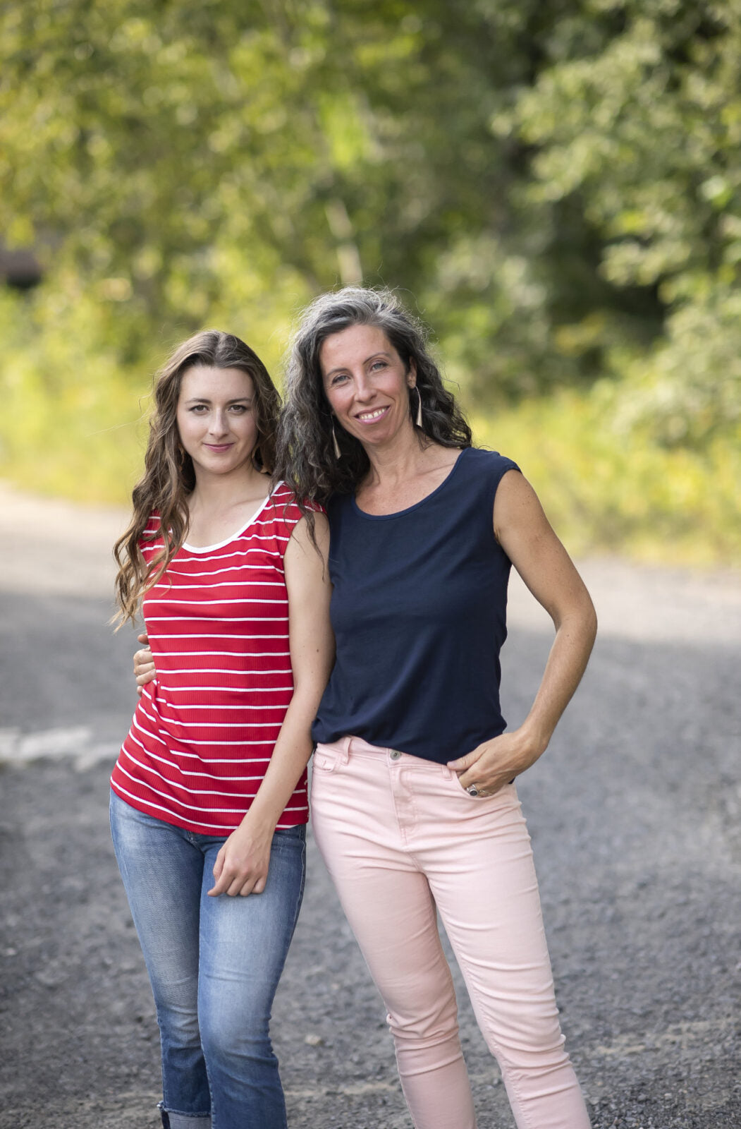 Two women wearing the Sol Top by Marie C, one in Navy and one in Red Stripe, with a scoop neck and cap sleeves. They are standing ion a gravel road.