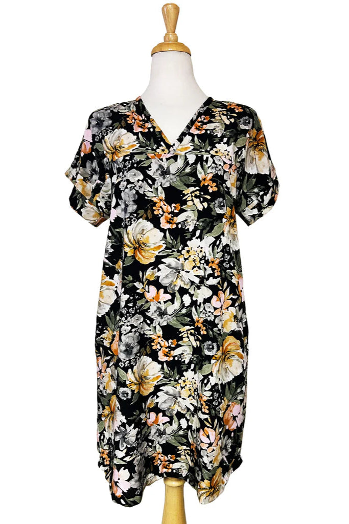 The Olivia Dress by Desserts and Skirts in Butter Floral, featuring short sleeves, a V-neck, a removable belt, and a knee length hem, is show on a mannequin in front of a white background. 