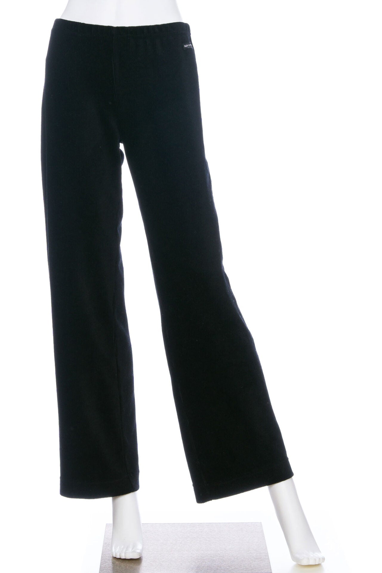 The Carex Pants by Rien ne se Perd in Black, relaxed fit pants with an elastic waist in stretchy corduroy, are shown on a mannequin in front of a white background. 