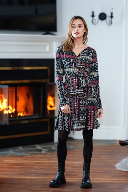 A woman wearing the Renoir Dress by Rien ne se Perd in Aztec, standing in front of a fireplace