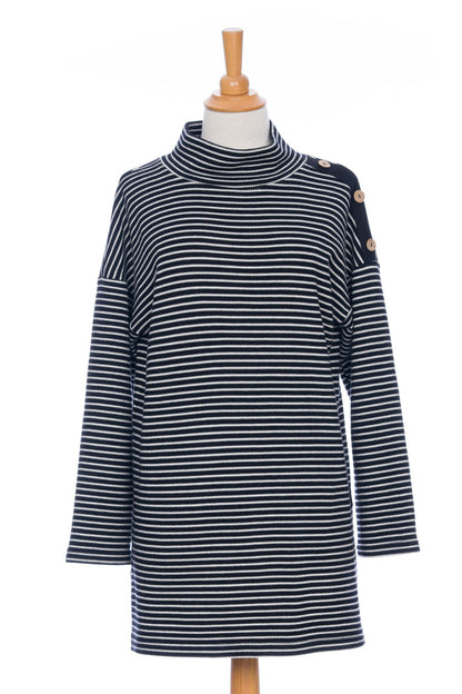 The Aralie Tunic by Rien ne se Perd in Black and White Stripe, with a high neckline, long sleeves, side slits for ease, drop sleeves and a coconut button placket on the left shoulder, is shown on a mannequin against a white background. 