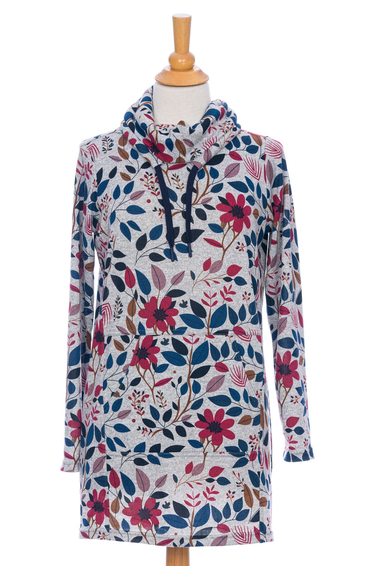 The Genevrier Tunic by Rien ne se Perd in Floral, featuring a turtleneck with a drawstring, a kangaroo pocket, long sleeves, and a straight cut, is shown on a mannequin in front of a white background. 