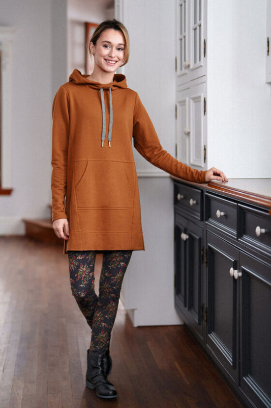 A woman wearing the Toulouse Tunic by Rien ne se Perd in Cognac, standing beside a set of cupboards