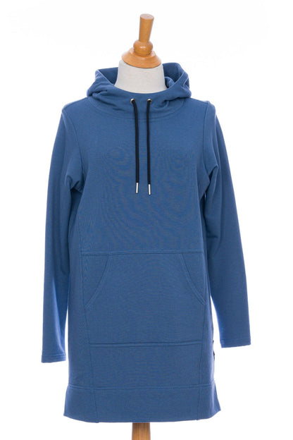 The Toundra Tunic by Rien ne se Perd in Blue, featuring a large hood with drawstrings, a kangaroo pocket, and a relaxed fit, is shown on a mannequin in front of a white background. 