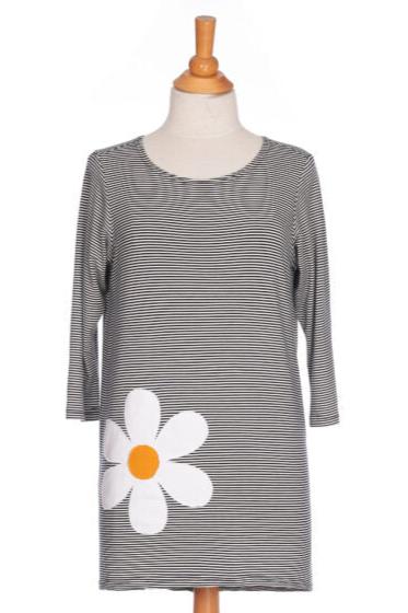 The Zumba Tunic by Rien ne se Perd, a striped navy and white piece with a boat neck, 3/4 sleeves, and a large daisy applique, is shown on a mannequin in front of a white background. 