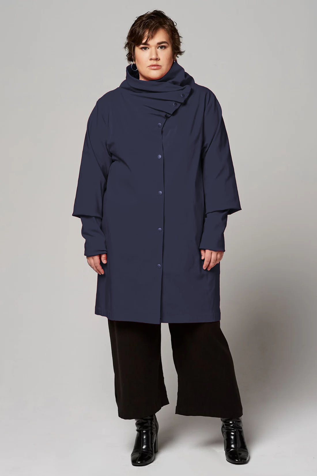 A woman wearing the Ubert Jacket by Melow in Navy, standing in front of a white background 