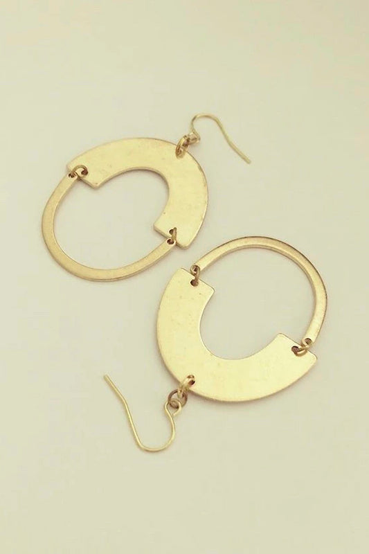 Ruuk dangle earrings by Darlings of Denmark; thin U-shape hanging off a wide arch shape; raw brass; flat lay