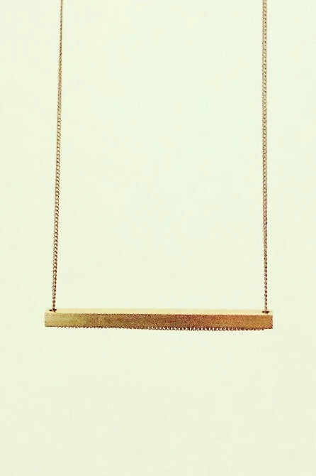 Slik necklace by Darlings of Denmark; raw brass; horizontal long solid bar; long chain; close-up shot